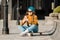 Girl sitting on skateboard and use mobile phone. Outdoors, urban lifestyle. cute skater girl sitting on skate board checking smart