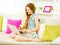 Girl sitting on sofa and typing on laptop