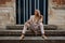 Girl sitting stairs medieval Romanesque door evening sun