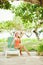 Girl sitting on sunbed near the tree