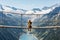 Girl Sitting on a Suspension Bridge Watching an Alpine Mountain Landscape