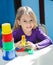 Girl Sitting With Toys At Desk In Preschool