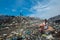 Girl sitting on trash near the road at garbage dump