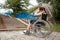The girl is sitting in a wheelchair facing difficulties alone, depressed. The concept of a wheelchair, disabled person, full life