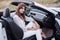 Girl sitting in a white cabriolet with open door