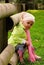 Girl sitting on the wooden fence in a park.