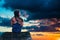 Girl sitting on wooden pier and looking in sky