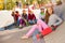 Girl with skateboard and friends sitting behind