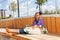 Girl with skateboard sits on wooden construction