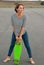 Girl with skateboard standing barefoot