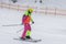 Girl skier in a bright suit on the slope, overalls. Winter sport concept, leisure outdoor lifestile