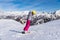 Girl skier in grey jacket and pink pants  on a slope rides