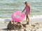 Girl in a skirt with a children\'s lifebuoy on a beach