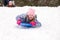 Girl Sledding Head First and Looking at Camera