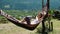 Girl sleeping in a hammock on the nature against the background of green mountains, slow motion