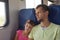 Girl sleeping leaning on dadâ€™s shoulder in an electric train car