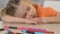 Girl sleeping on table in kindergarten, exhausted after tiring art lesson, close