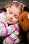 Girl sleeping with teddy bear