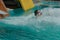 Girl slides down from the slide into the pool