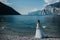 A girl in a smart white dress walks along the embankment of lake Garda.A woman is photographed against the background of a