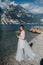 A girl in a smart white dress walks along the embankment of lake Garda.A woman is photographed against the background of a