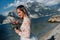 A girl in a smart white dress walks along the embankment of lake Garda.A woman is photographed against the background of a