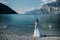 A girl in a smart white dress walks along the embankment of lake Garda.A woman is photographed against the background of a