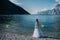 A girl in a smart white dress walks along the embankment of lake Garda.A woman is photographed against the background of a