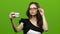 Girl of with a smartphone in her hands makes selfie. Green screen