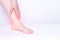 Girl smears medical ointment ankle on a white background, treatment of synovitis and bursitis, inflammation, copy space,