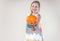 girl with a smile holds a pumpkin in her hands