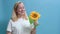 The girl smiles and accepts a gift from a man in the form of flower sunflowers