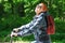 The girl smiles happily. Riding in the Park on a Bicycle path. Face exposed to sunlight