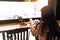 Girl smiling, drinks coffee in cafe and reading phone. Blurred background