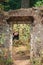 Girl smiling in forest, young woman smiling at door ruin in forest, outdoor travel concept