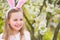 Girl smiling in garden with blurred blossoming trees