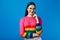 Girl smiling and holding hands partly crossed, wears rainbow sweater