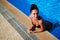 Girl smiling while leaning on the edge of the pool