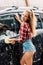 Girl smiling while washing wet car with foam