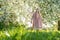 A girl sniffs a beautiful white apple tree, spring in the midst of the flowering of the apple tree is beautiful apple in