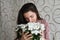 Girl sniffs a bouquet of white flowers. Brunette hugs sniffs a bouquet of delicate flowers from her beloved. A nice gift for your