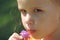Girl sniffs a lilac bunch of flowers puffy lips serious look