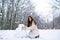 Girl in snow. Enjoying nature wintertime. Winter woman happy. Beautiful girl in the winter forest in white down jacket.