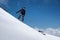 Girl snowboarder with a backpack on a snowy fresh slope against the backdrop of high mountains and blue sky. Winter