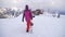 Girl snowboarder holding snowboard in hands at the ski resort. Sport woman in snowy mountains. Sunny winter day in ski