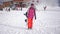 Girl snowboarder holding snowboard in hands at the ski resort. Sport woman in snowy mountains. Sunny winter day in ski