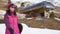 Girl snowboarder holding snowboard in hands at the ski resort. Sport woman in snowy mountains. Sunny winter day in ski