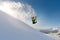 Girl snowboarder jumping front flip leaving a wave of snow