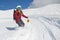 Girl snowboarder rides a snowboard towed holding rope.