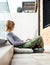 Girl social media influencer sitting on patio floor using laptop